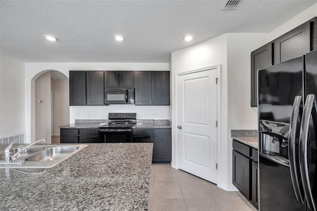 30732 Summer Sun Loop, Wesley Chapel, FL 33545 - kitchen featuring black appliances, arched walkways, recessed lighting, light tile patterned floors, and a textured ceiling