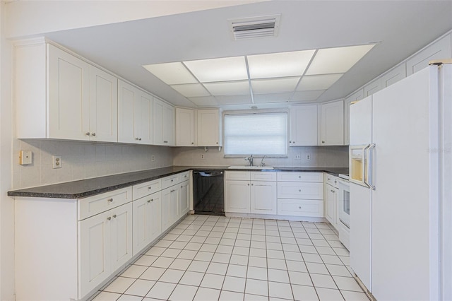 739 Chesapeake Dr, Tarpon Springs, FL 34689 - kitchen featuring white refrigerator with ice dispenser, dishwasher, tasteful backsplash, dark countertops, and light tile patterned floors