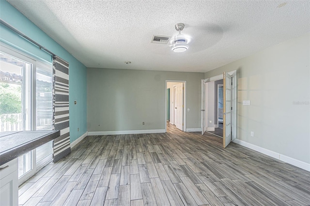 739 Chesapeake Dr, Tarpon Springs, FL 34689 - unfurnished room with light wood-style flooring, a textured ceiling, and a ceiling fan