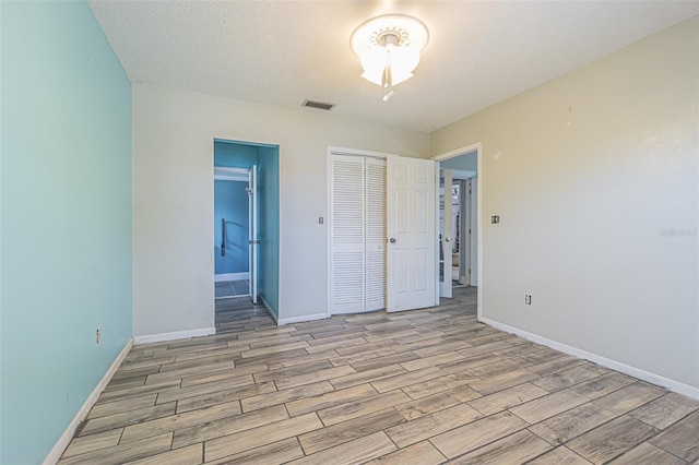 739 Chesapeake Dr, Tarpon Springs, FL 34689 - unfurnished bedroom with light wood finished floors, a closet, and ensuite bathroom