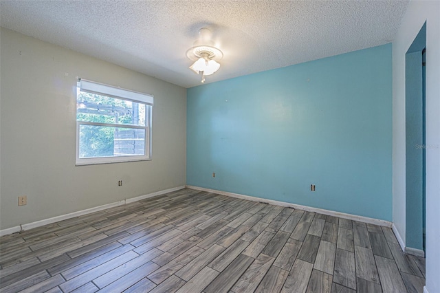 739 Chesapeake Dr, Tarpon Springs, FL 34689 - empty room with wood finished floors and a textured ceiling