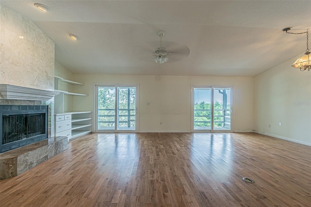 739 Chesapeake Dr, Tarpon Springs, FL 34689 - unfurnished living room with lofted ceiling, a ceiling fan, wood finished floors, and a tile fireplace
