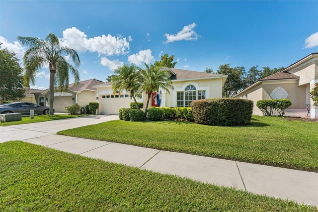 10409 Glen Willow Ln, Tampa, FL 33647 - view of front of property with concrete driveway, stucco siding, an attached garage, and a front lawn