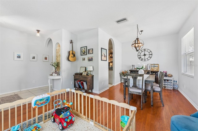 10409 Glen Willow Ln, Tampa, FL 33647 - dining area with arched walkways, wood finished floors, and a chandelier