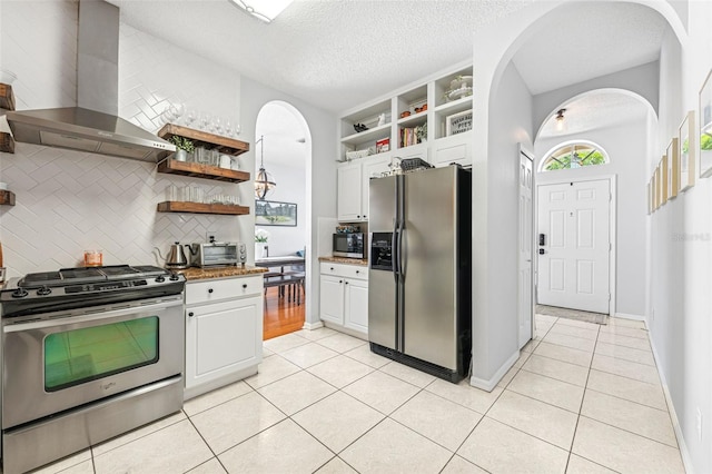 10409 Glen Willow Ln, Tampa, FL 33647 - kitchen with appliances with stainless steel finishes, wall chimney exhaust hood, open shelves, arched walkways, and light tile patterned floors