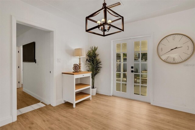 1320 Dixie Ln S, Saint Petersburg, FL 33707 - dining area with a chandelier, light wood-type flooring, and french doors