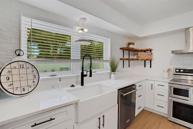 1320 Dixie Ln S, Saint Petersburg, FL 33707 - kitchen with appliances with stainless steel finishes, wall chimney exhaust hood, open shelves, and white cabinetry
