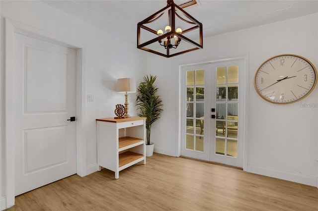 1320 Dixie Ln S, Saint Petersburg, FL 33707 - doorway to outside with french doors, a chandelier, and wood finished floors