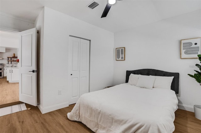 1320 Dixie Ln S, Saint Petersburg, FL 33707 - bedroom featuring wood finished floors, a closet, ceiling fan, and a wall mounted AC