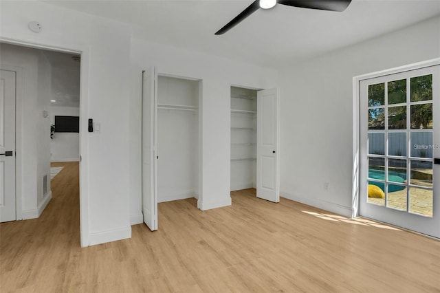 1320 Dixie Ln S, Saint Petersburg, FL 33707 - unfurnished bedroom featuring light wood finished floors, two closets, and a ceiling fan