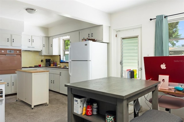 4917 99th St N, Saint Petersburg, FL 33708 - kitchen with oven, tasteful backsplash, a center island, under cabinet range hood, and wood counters
