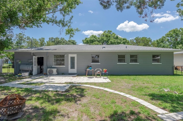 4917 99th St N, Saint Petersburg, FL 33708 - back of house featuring a fire pit, a patio, and a lawn