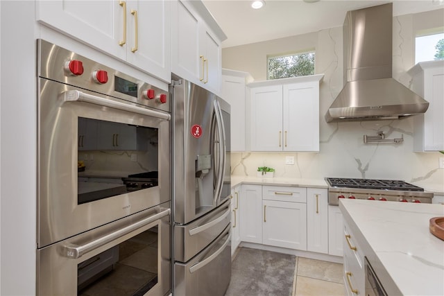 3042 Wentworth Way, Tarpon Springs, FL 34688 - kitchen with appliances with stainless steel finishes, wall chimney range hood, backsplash, white cabinets, and healthy amount of natural light