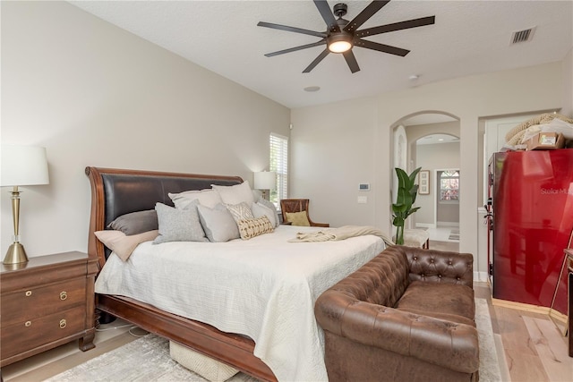 3042 Wentworth Way, Tarpon Springs, FL 34688 - bedroom with light wood-style floors, arched walkways, refrigerator, and a ceiling fan