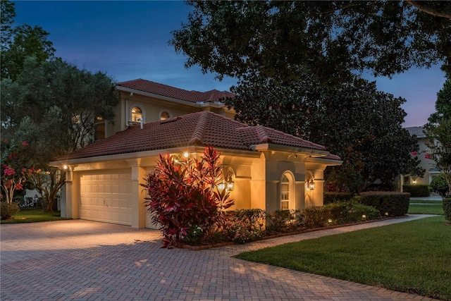 3042 Wentworth Way, Tarpon Springs, FL 34688 - mediterranean / spanish home with stucco siding, decorative driveway, a tiled roof, an attached garage, and a front lawn