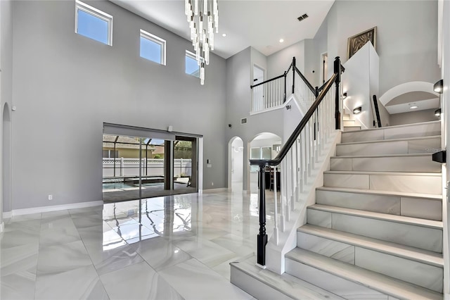 3241 Evening Breeze Loop, Wesley Chapel, FL 33544 - staircase featuring arched walkways, a towering ceiling, and marble finish floors