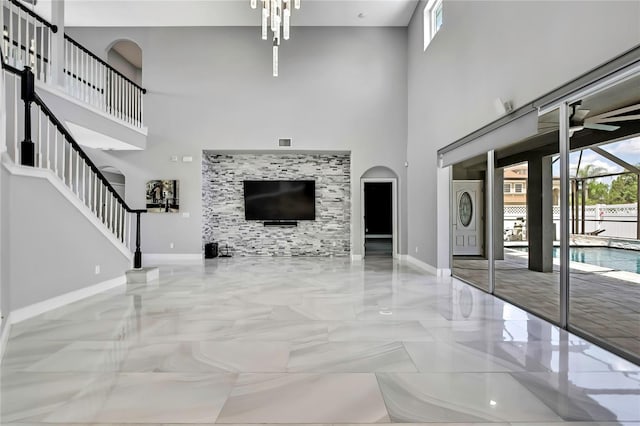 3241 Evening Breeze Loop, Wesley Chapel, FL 33544 - unfurnished living room with a high ceiling, arched walkways, marble tiled floors, and stairway