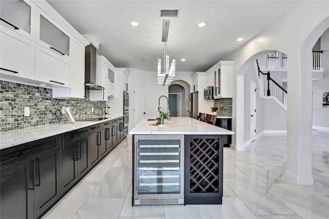 3241 Evening Breeze Loop, Wesley Chapel, FL 33544 - kitchen with beverage cooler, appliances with stainless steel finishes, arched walkways, tasteful backsplash, and recessed lighting