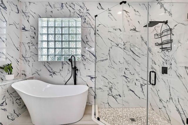 3241 Evening Breeze Loop, Wesley Chapel, FL 33544 - bathroom featuring a soaking tub, a marble finish shower, stone wall, tile walls, and marble tiled floors