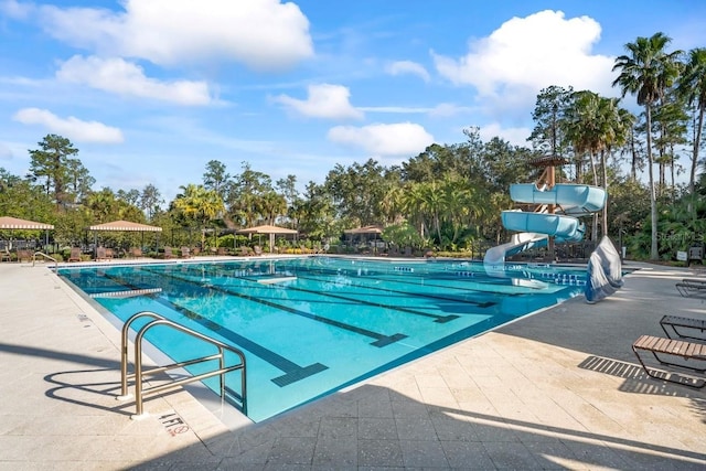 3241 Evening Breeze Loop, Wesley Chapel, FL 33544 - community pool featuring a water slide, a patio, and view of wooded area