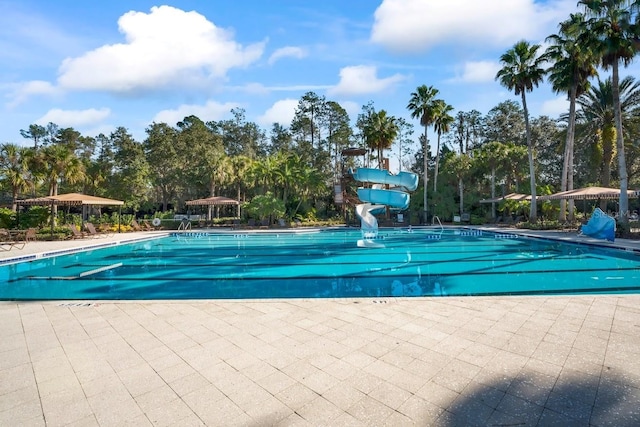 3241 Evening Breeze Loop, Wesley Chapel, FL 33544 - community pool featuring a water slide, view of wooded area, and a patio area
