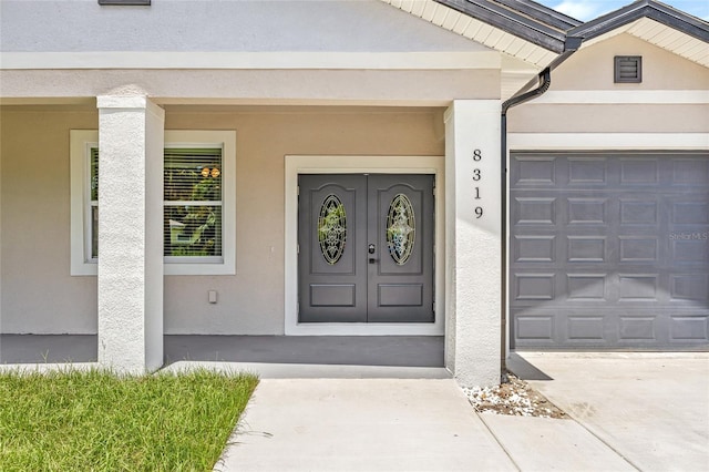 8319 N Ogontz Ave, Tampa, FL 33604 - entrance to property featuring stucco siding, driveway, and a garage