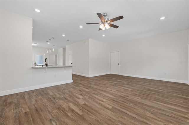 8319 N Ogontz Ave, Tampa, FL 33604 - unfurnished living room with wood finished floors, ceiling fan, and recessed lighting