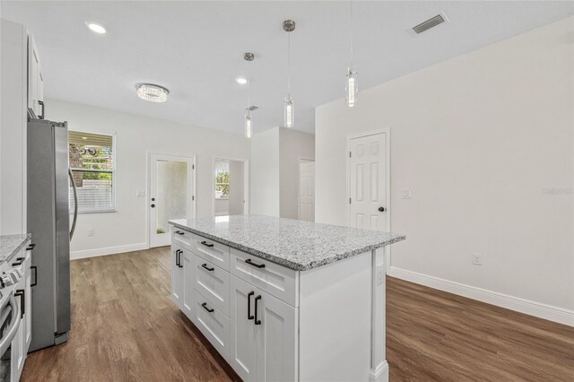 8319 N Ogontz Ave, Tampa, FL 33604 - kitchen with freestanding refrigerator, dark wood-style floors, a center island, white cabinetry, and decorative light fixtures