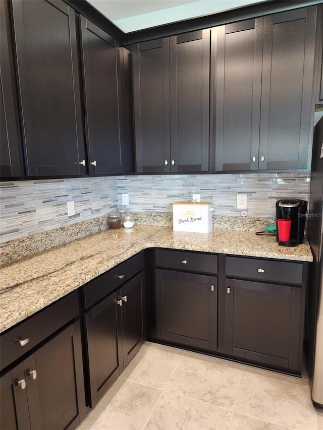 12351 Nouveau Ave, Spring Hill, FL 34610 - kitchen with tasteful backsplash, light stone countertops, freestanding refrigerator, and light tile patterned flooring