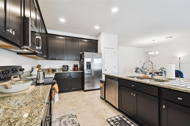 12351 Nouveau Ave, Spring Hill, FL 34610 - kitchen with appliances with stainless steel finishes, a chandelier, light stone counters, pendant lighting, and recessed lighting