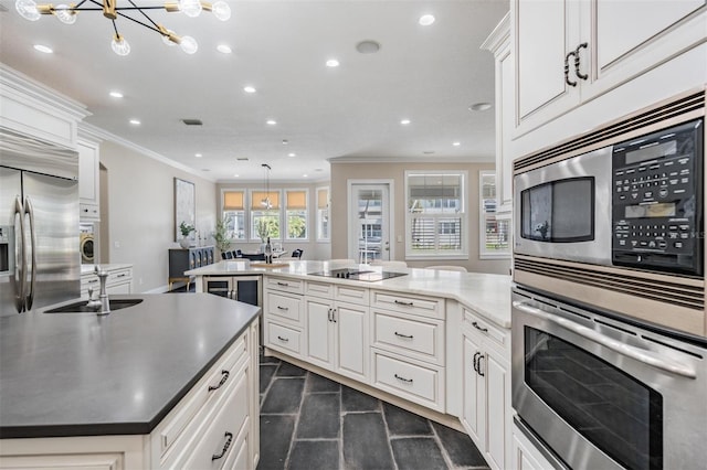 650 Geneva Pl, Tampa, FL 33606 - kitchen featuring appliances with stainless steel finishes, ornamental molding, recessed lighting, a peninsula, and a chandelier