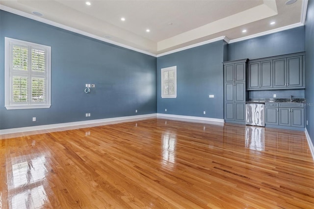 650 Geneva Pl, Tampa, FL 33606 - unfurnished living room with light wood finished floors, a tray ceiling, ornamental molding, and recessed lighting