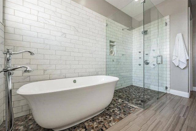 650 Geneva Pl, Tampa, FL 33606 - full bathroom with a shower stall, a freestanding bath, wood finished floors, and tile walls