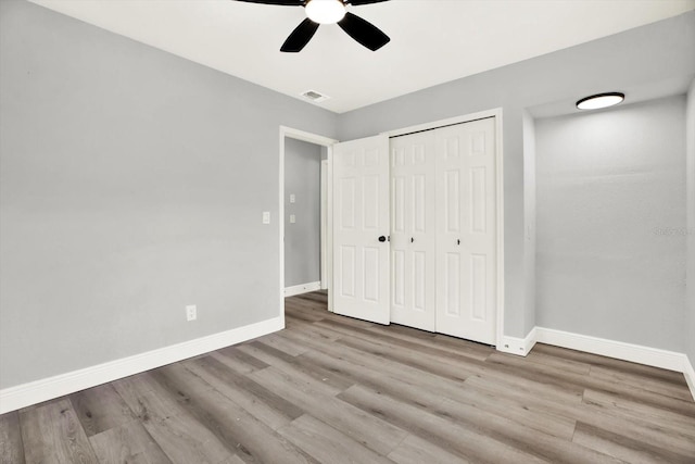 1223 Jasmine Way, Clearwater, FL 33756 - unfurnished bedroom featuring wood finished floors, a closet, and a ceiling fan