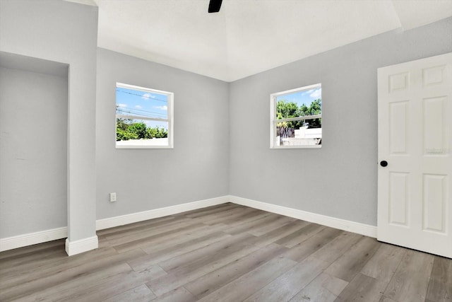 1223 Jasmine Way, Clearwater, FL 33756 - unfurnished bedroom featuring multiple windows, wood finished floors, and a ceiling fan