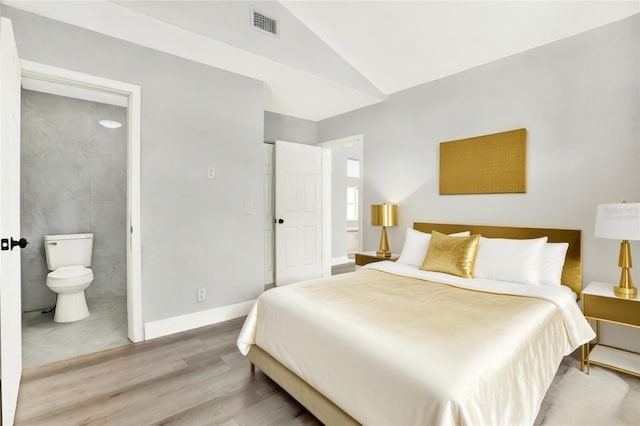 1223 Jasmine Way, Clearwater, FL 33756 - bedroom featuring wood finished floors, vaulted ceiling, and connected bathroom