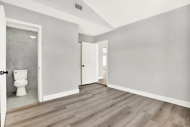 1223 Jasmine Way, Clearwater, FL 33756 - unfurnished bedroom with wood finished floors, lofted ceiling, and connected bathroom