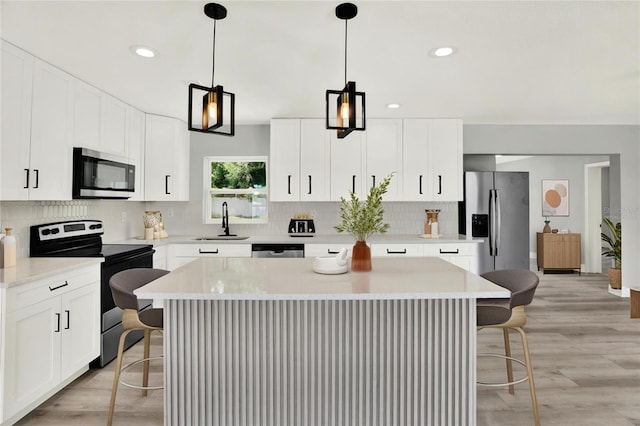 1223 Jasmine Way, Clearwater, FL 33756 - kitchen with appliances with stainless steel finishes, a kitchen breakfast bar, backsplash, a kitchen island, and recessed lighting