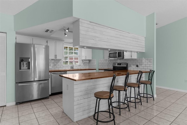 5112 Odin St, Spring Hill, FL 34608 - kitchen featuring stainless steel appliances, light tile patterned flooring, white cabinetry, and tasteful backsplash