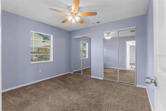 5112 Odin St, Spring Hill, FL 34608 - unfurnished bedroom featuring multiple closets, carpet flooring, ceiling fan, and a textured ceiling