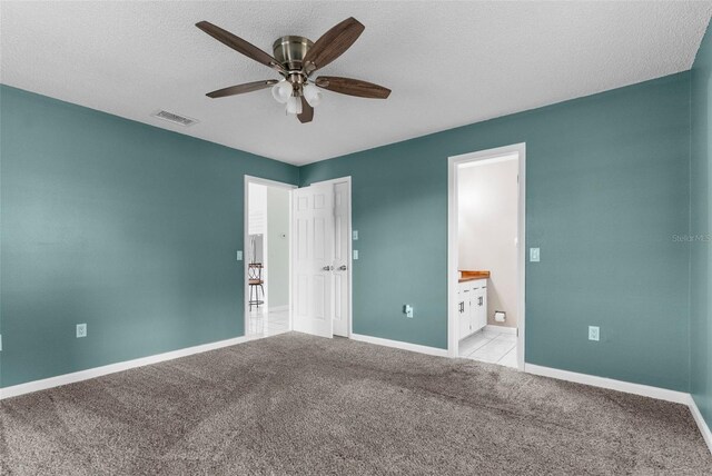 5112 Odin St, Spring Hill, FL 34608 - unfurnished bedroom featuring ensuite bathroom, carpet floors, a textured ceiling, and ceiling fan