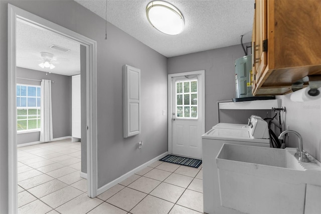 5112 Odin St, Spring Hill, FL 34608 - laundry room with a textured ceiling, cabinet space, separate washer and dryer, light tile patterned floors, and a ceiling fan