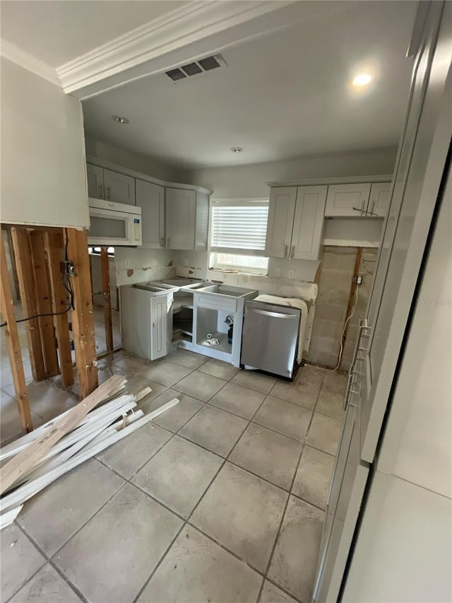 1782 Michigan Ave NE, Saint Petersburg, FL 33703 - kitchen with dishwasher, ornamental molding, white microwave, light tile patterned floors, and light countertops