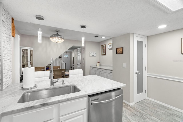 3323 Fox Hunt Dr, Palm Harbor, FL 34683 - kitchen with stainless steel dishwasher, light wood-type flooring, a textured ceiling, white cabinets, and light stone counters