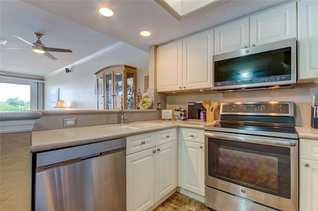 163 Brent Cir, Oldsmar, FL 34677 - kitchen featuring appliances with stainless steel finishes, crown molding, white cabinetry, a ceiling fan, and light countertops