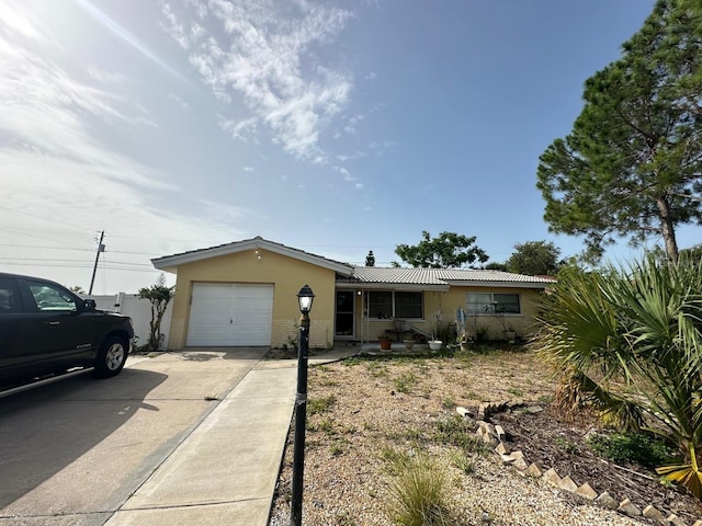 single story home with an attached garage, driveway, and stucco siding