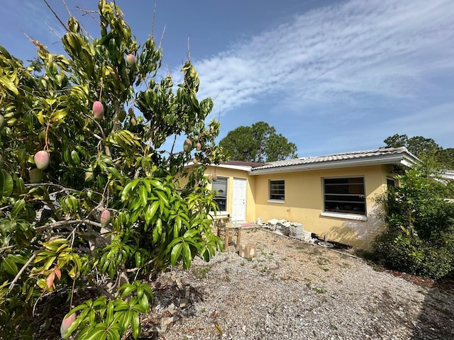 rear view of property featuring stucco siding
