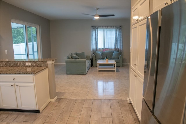 25435 Bruford Blvd, Land O Lakes, FL 34639 - kitchen with freestanding refrigerator, white cabinets, ceiling fan, and plenty of natural light