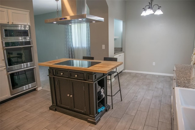 25435 Bruford Blvd, Land O Lakes, FL 34639 - kitchen featuring ventilation hood, appliances with stainless steel finishes, light wood-style floors, butcher block counters, and white cabinets