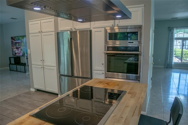 25435 Bruford Blvd, Land O Lakes, FL 34639 - kitchen with appliances with stainless steel finishes, wooden counters, and white cabinetry
